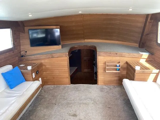 Slide: The Image of Interior of 2022 Custom Carolina Sportfish with wooden finish, TV, and seating area. - 8