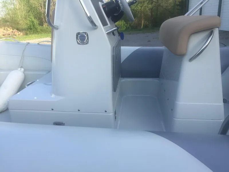 Slide: The Image of 2017 Zodiac Medline 580 boat interior with steering console and seating. - 2