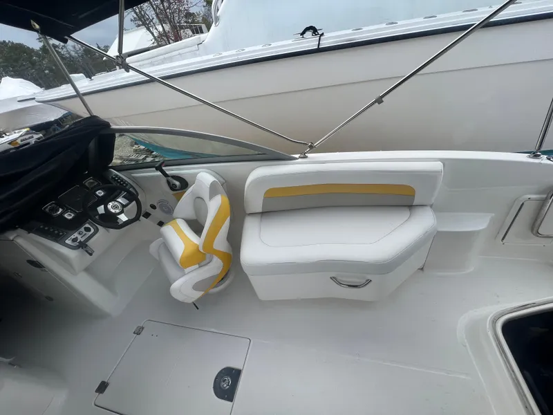 Slide: The Image of 2012 Chaparral 264 Sunesta boat interior with white and yellow seating. - 10