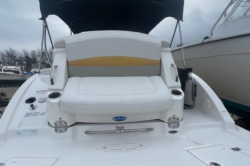 Slide: The Image of 2012 Chaparral 264 Sunesta boat with white and yellow seating, docked. - 14