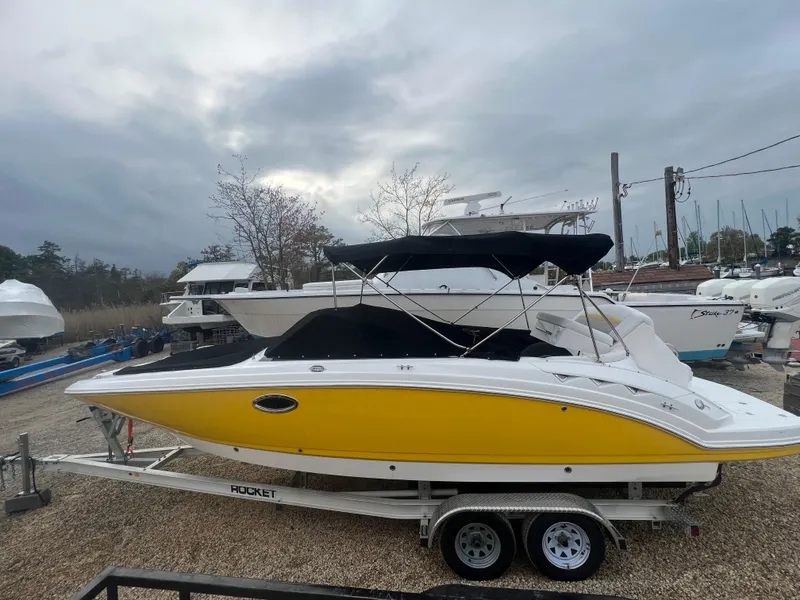 Slide: The Image of 2012 Chaparral 264 Sunesta boat with yellow hull on a trailer. - 2