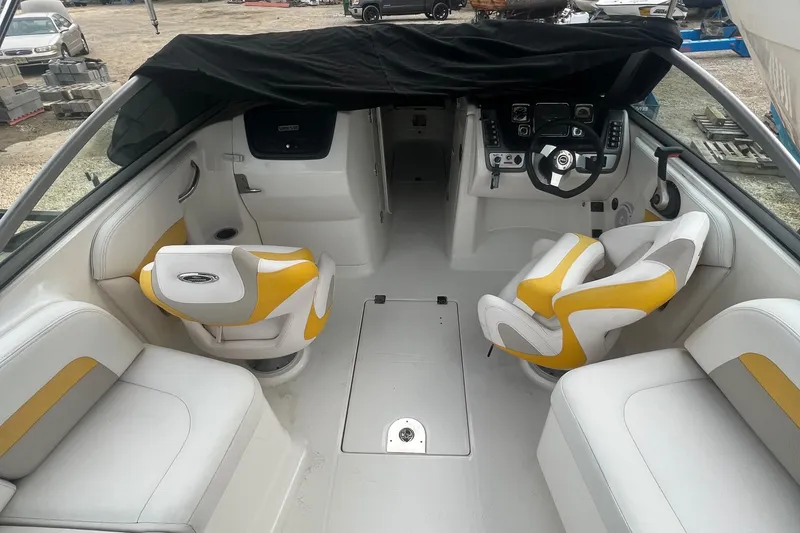 Slide: The Image of 2012 Chaparral 264 Sunesta boat interior with white and yellow seating. - 9