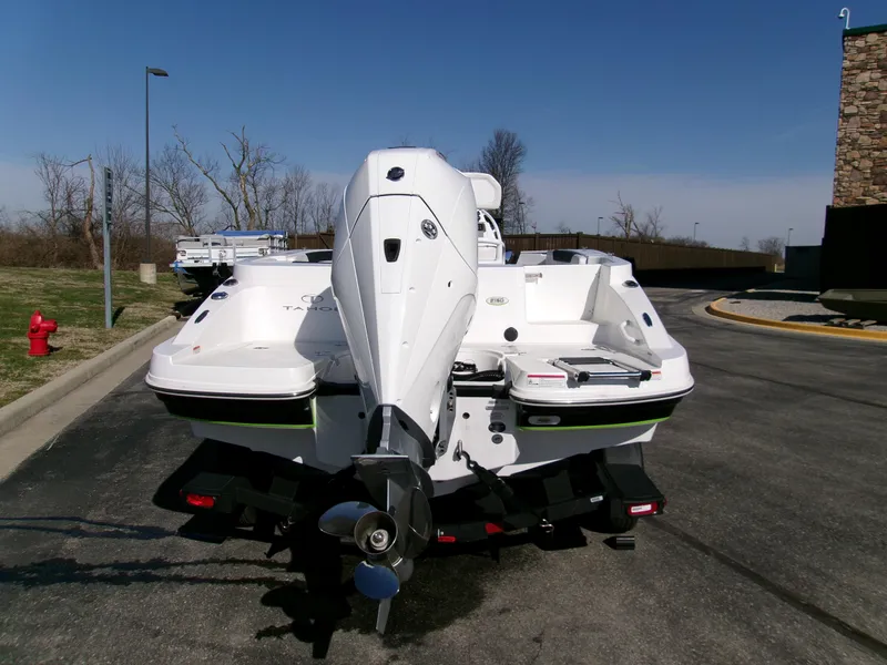 Slide: The Image of 2024 Tahoe 2150 CC boat, rear view, parked on pavement under clear sky. - 3