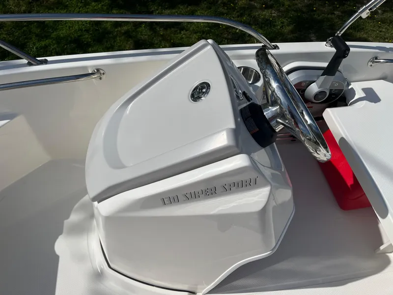 Slide: The Image of 2025 Boston Whaler 130 Super Sport boat console with steering wheel and controls. - 10