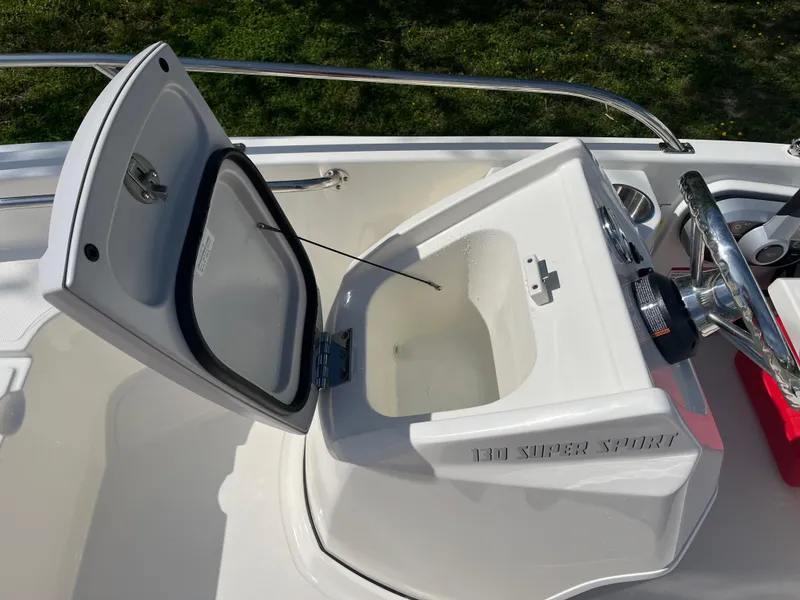 Slide: The Image of 2025 Boston Whaler 130 Super Sport boat console with open storage compartment. - 11