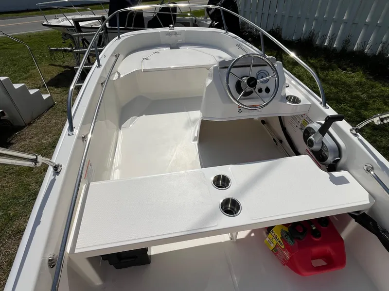 Slide: The Image of 2025 Boston Whaler 130 Super Sport boat interior with steering wheel and seating. - 13