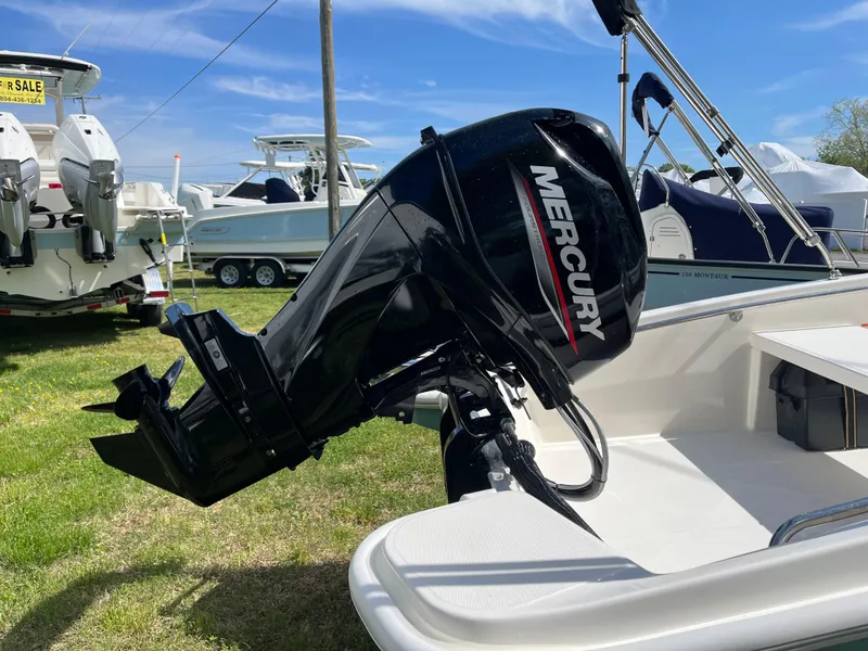 Slide: The Image of 2025 Boston Whaler 130 Super Sport with Mercury outboard motor, displayed outdoors. - 17