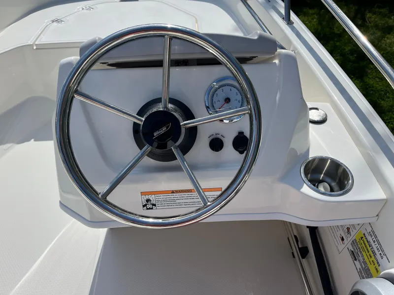 Slide: The Image of 2025 Boston Whaler 130 Super Sport steering console with stainless steel wheel and gauges. - 6
