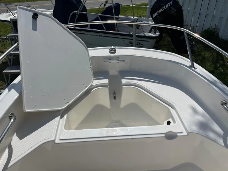 Slide: The Image of 2025 Boston Whaler 130 Super Sport boat with open storage compartment. - 9
