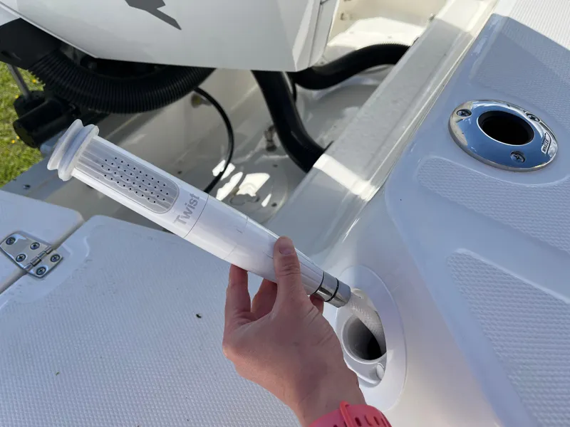 Slide: The Image of Hand holding a device on a 2025 Boston Whaler 280 Dauntless boat deck. - 23