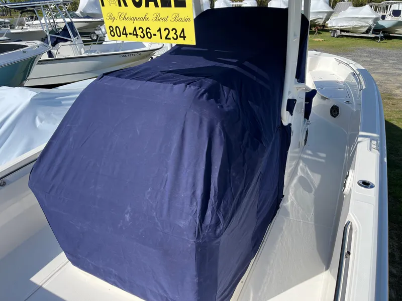 Slide: The Image of 2025 Boston Whaler 280 Dauntless boat with blue cover, displayed outdoors. - 28