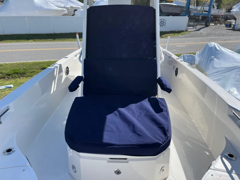 Slide: The Image of 2025 Boston Whaler 280 Dauntless boat seat with blue cushions, docked outdoors. - 29