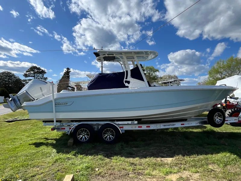 Slide: The Image of 2025 Boston Whaler 280 Dauntless boat on trailer, parked on grass under a blue sky. - 31