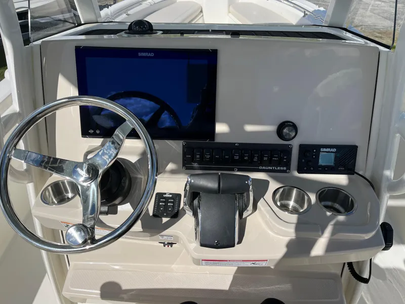 Slide: The Image of 2025 Boston Whaler 280 Dauntless helm with steering wheel, controls, and navigation display. - 5