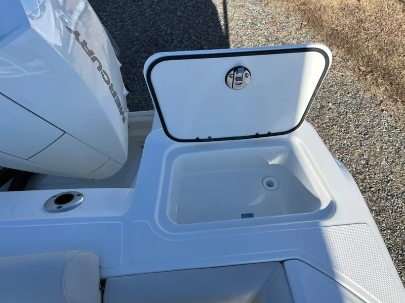 Slide: The Image of 2025 Boston Whaler 250 Outrage boat with open storage compartment and Mercury engine. - 10