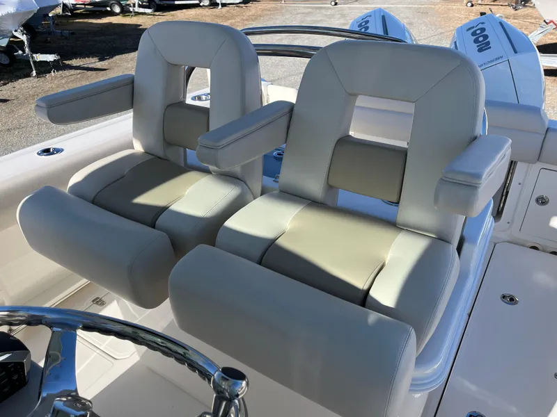 Slide: The Image of 2025 Boston Whaler 250 Outrage boat seats with armrests and steering wheel. - 18