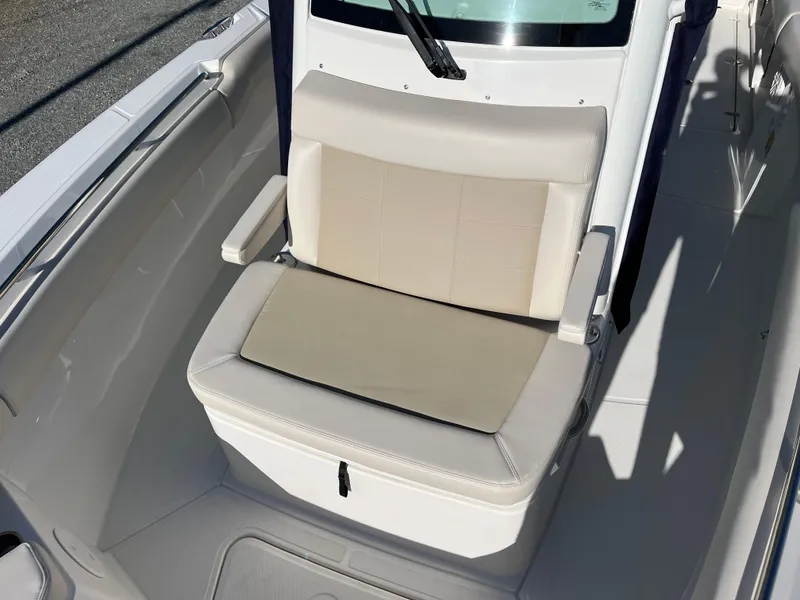 Slide: The Image of 2025 Boston Whaler 250 Outrage boat seat with beige cushions and armrests. - 21