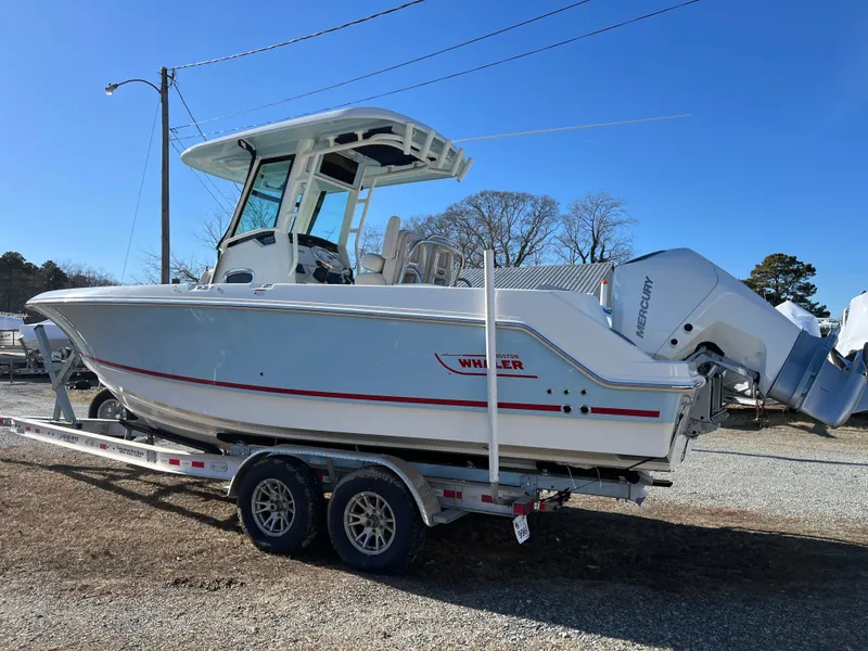 Slide: The Image of 2025 Boston Whaler 250 Outrage boat on trailer, side view, clear sky background. - 34