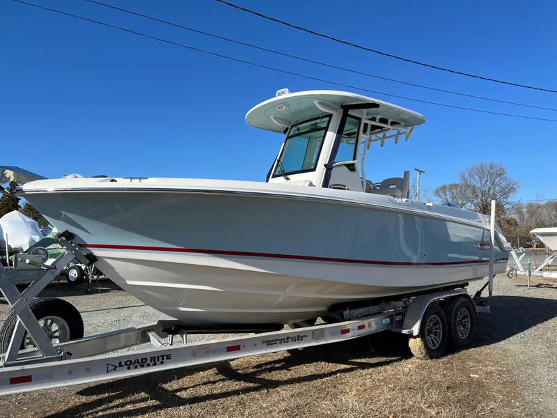 Slide: The Image of 2025 Boston Whaler 250 Outrage boat on trailer, clear sky background. - 35