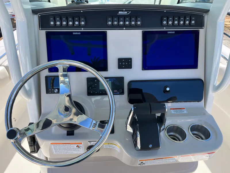 Slide: The Image of Control panel of 2025 Boston Whaler 250 Outrage with dual screens and steering wheel. - 5