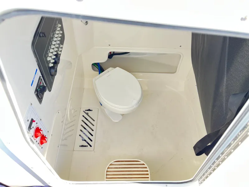 Slide: The Image of Interior of 2025 Boston Whaler 250 Outrage boat featuring a compact marine toilet. - 6