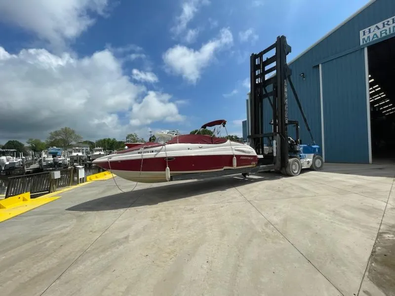 Slide: The Image of 2005 Chaparral 2300 boat being lifted by a forklift at a marina. - 8