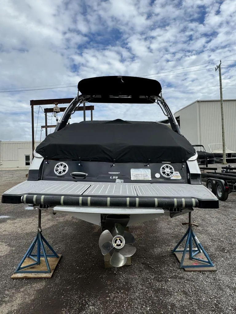 Slide: The Image of 2024 Regal LS9 boat on stands, rear view with covered deck and propeller. - 3