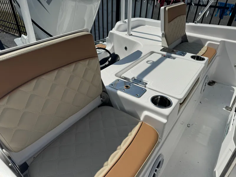 Slide: The Image of 2024 NauticStar 211 Hybrid boat interior with beige quilted seats and fishing station. - 3