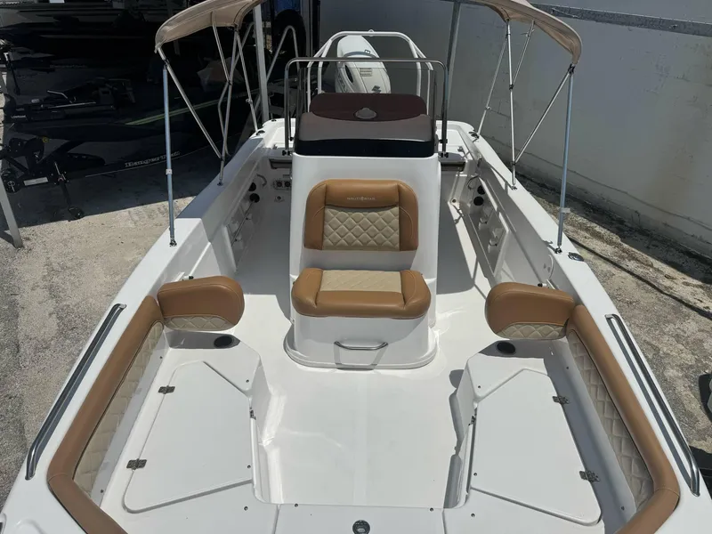 Slide: The Image of 2024 NauticStar 211 Hybrid boat interior with tan seating and bimini top. - 4