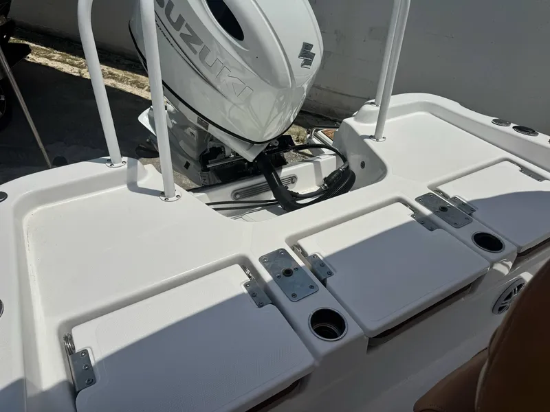 Slide: The Image of 2024 NauticStar 211 Hybrid boat with Suzuki outboard motor, featuring storage compartments and cup holders. - 7