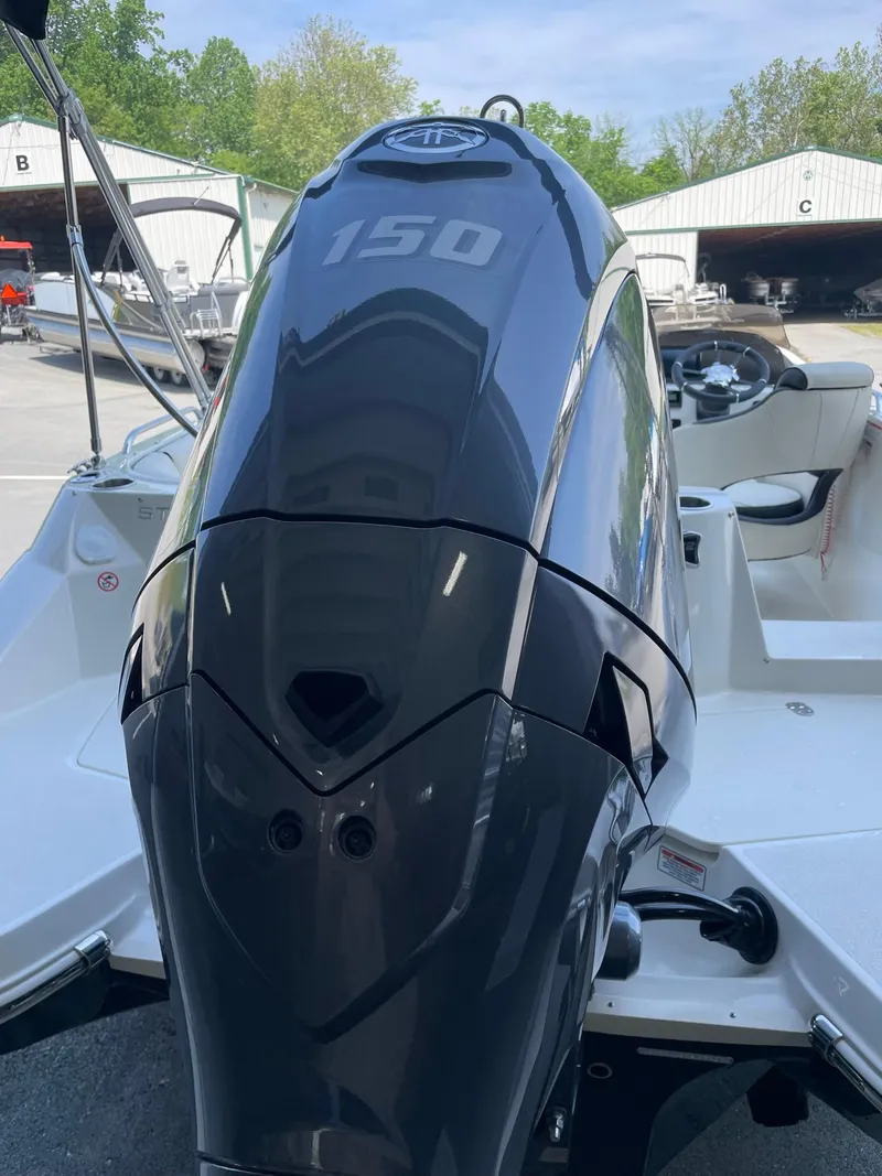 Slide: The Image of 2024 Stingray 212 SC boat with a 150 HP engine in a marina. - 3