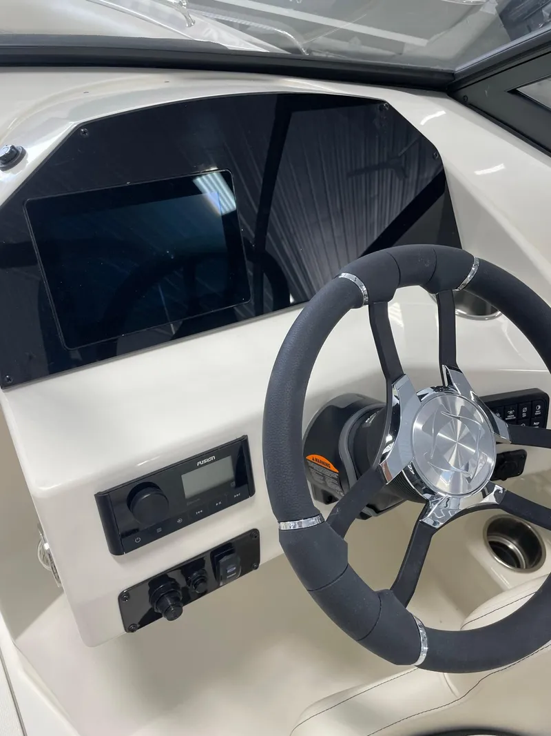Slide: The Image of 2024 Stingray 201 DC boat dashboard with steering wheel and control panel. - 10