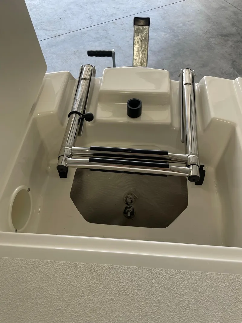 Slide: The Image of 2024 Stingray 201 DC boat with a built-in swim ladder and storage compartment. - 14