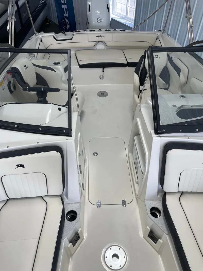 Slide: The Image of 2024 Stingray 201 DC boat interior with dual consoles and spacious seating. - 15