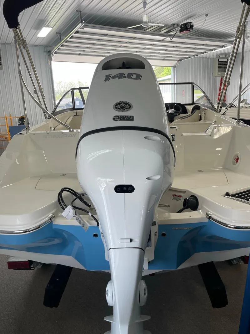 Slide: The Image of 2024 Stingray 201 DC boat with powerful outboard motor in a garage. - 5