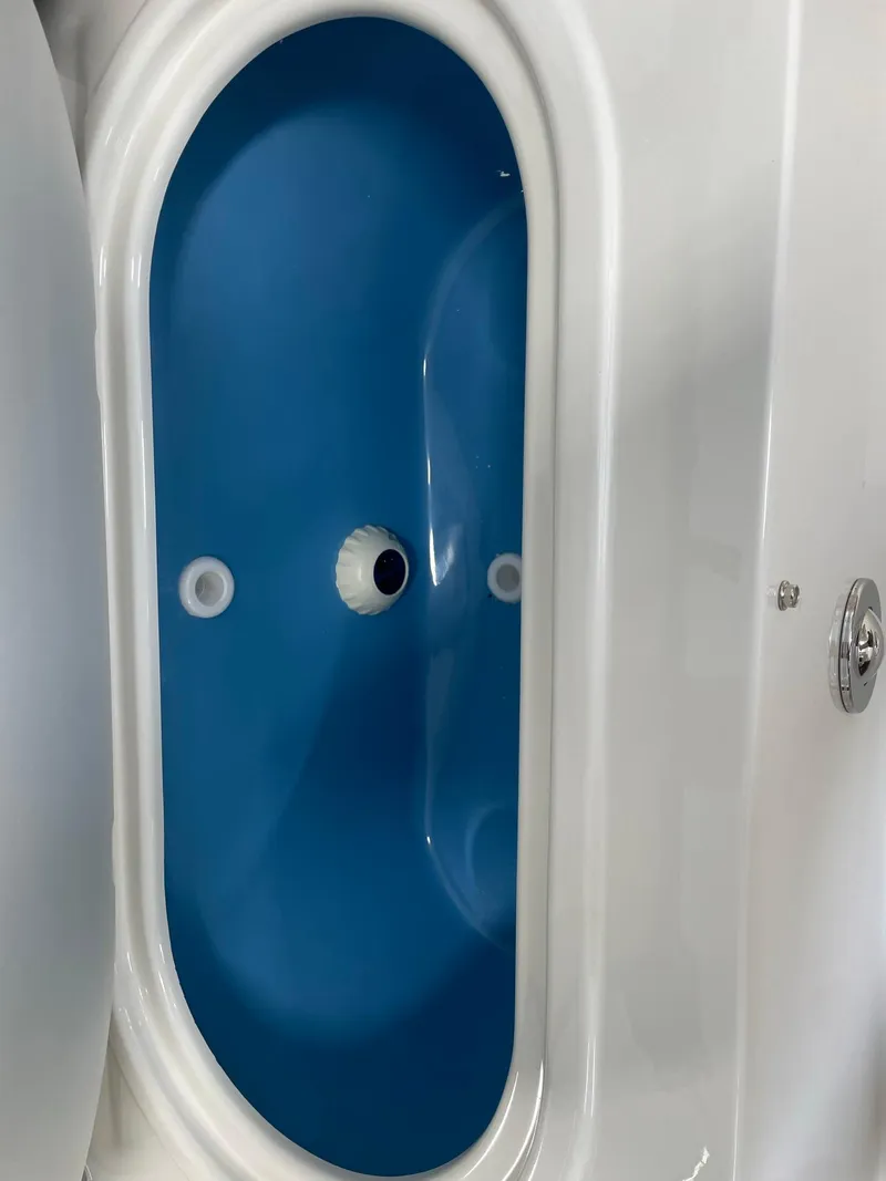 Slide: The Image of 2024 Stingray 201 DC boat livewell with blue interior. - 8