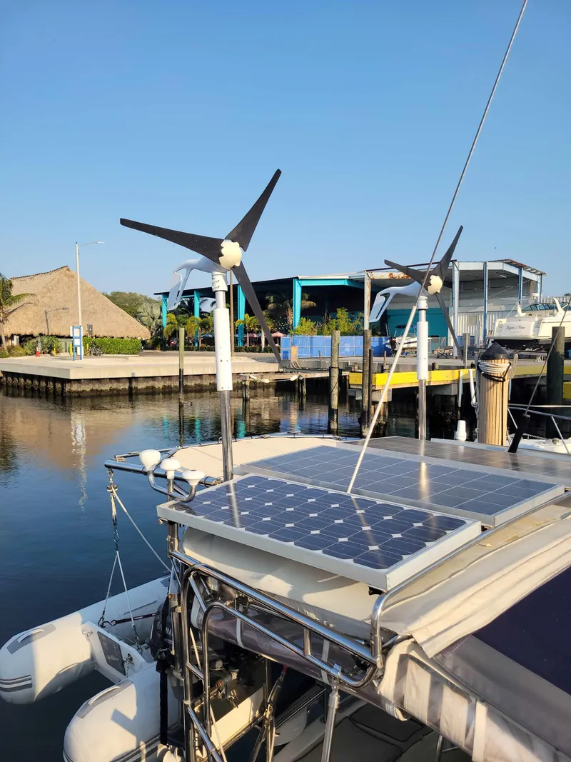 Slide: The Image of Caliber 40 LRC SE 2005 sailboat with solar panels and wind turbines at a marina. - 22