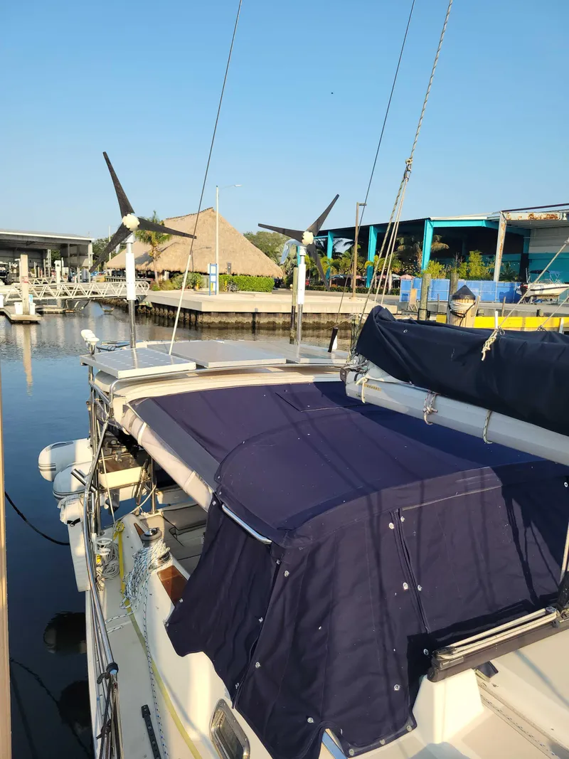 Slide: The Image of 2005 Caliber 40 LRC SE sailboat docked at a marina, featuring blue canvas covers. - 34