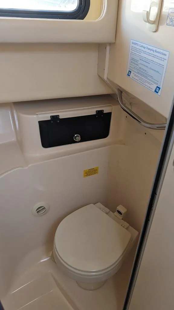 Slide: The Image of 2006 Grady-White Marlin 300 boat bathroom with toilet and storage compartment. - 15