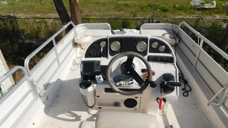 Slide: The Image of 2006 Hurricane 22 Deck Boat cockpit with steering wheel and control panel. - 15