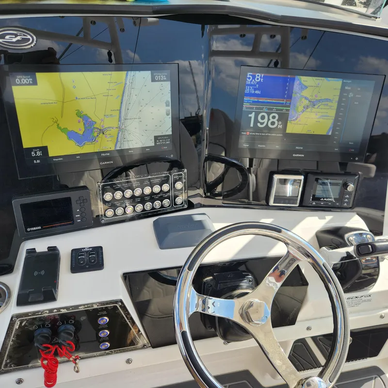 Slide: The Image of Sea Fox 328 Commander 2020 boat dashboard with navigation screens and controls. - 25