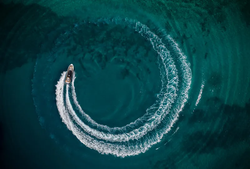 Slide: The Image of Aerial view of Custom 44S boat making circular waves in turquoise water, 2025 model. - 5