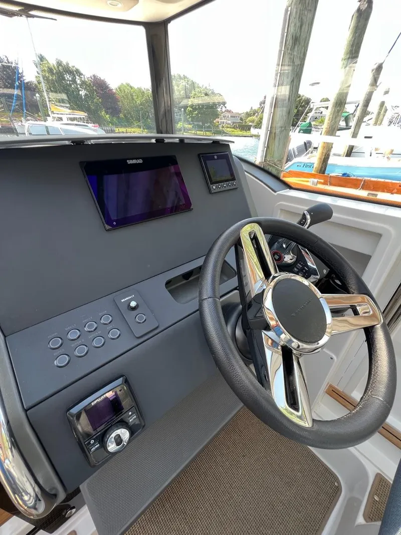 Slide: The Image of 2023 Nimbus C9 boat dashboard with steering wheel and electronic controls. - 10