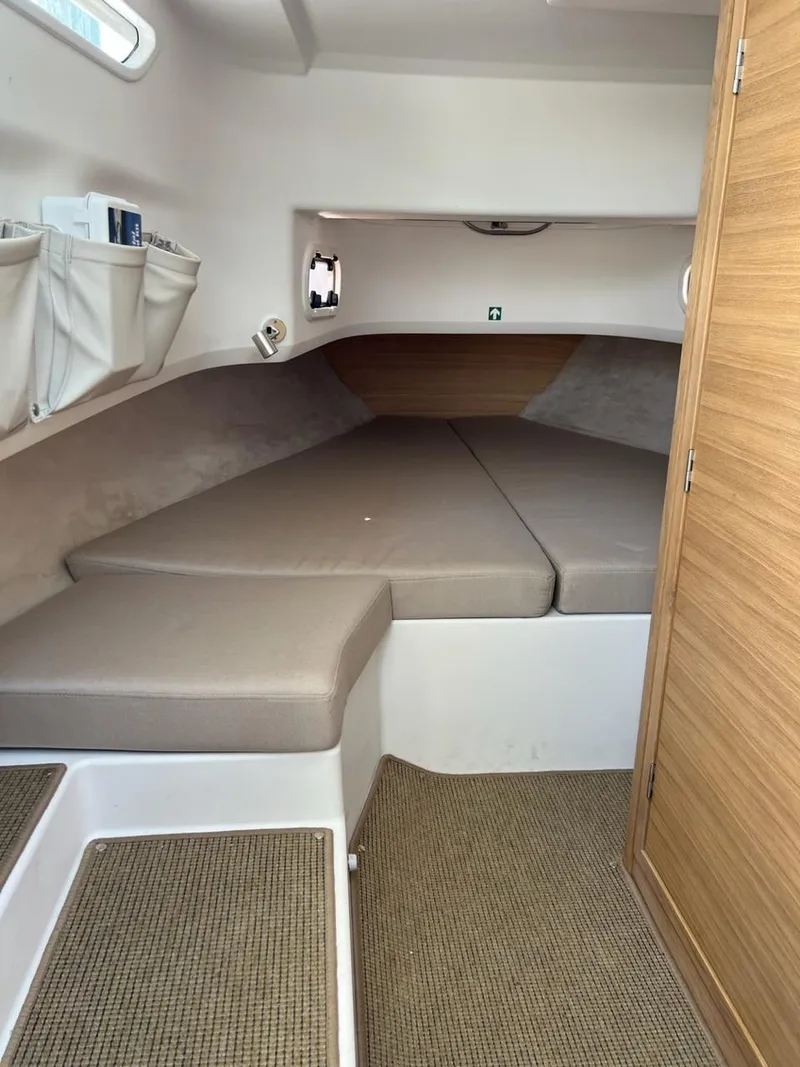 Slide: The Image of Interior cabin of 2023 Nimbus C9 boat with beige cushions and wooden accents. - 14