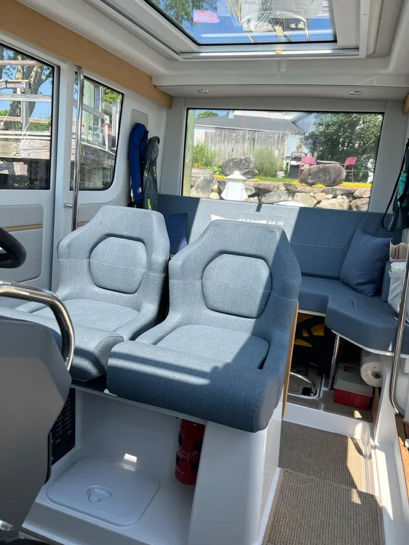 Slide: The Image of Interior of 2023 Nimbus C9 boat with blue seating and panoramic windows. - 15