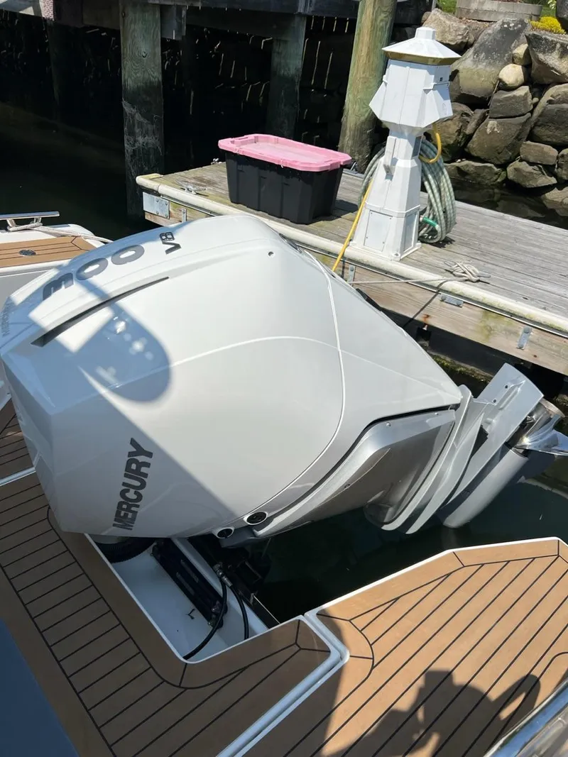 Slide: The Image of 2023 Nimbus C9 boat with a Mercury outboard motor docked at a marina. - 17