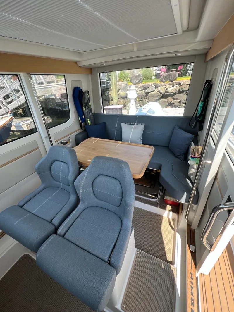 Slide: The Image of Interior of 2023 Nimbus C9 boat with blue seating and wooden table. - 6