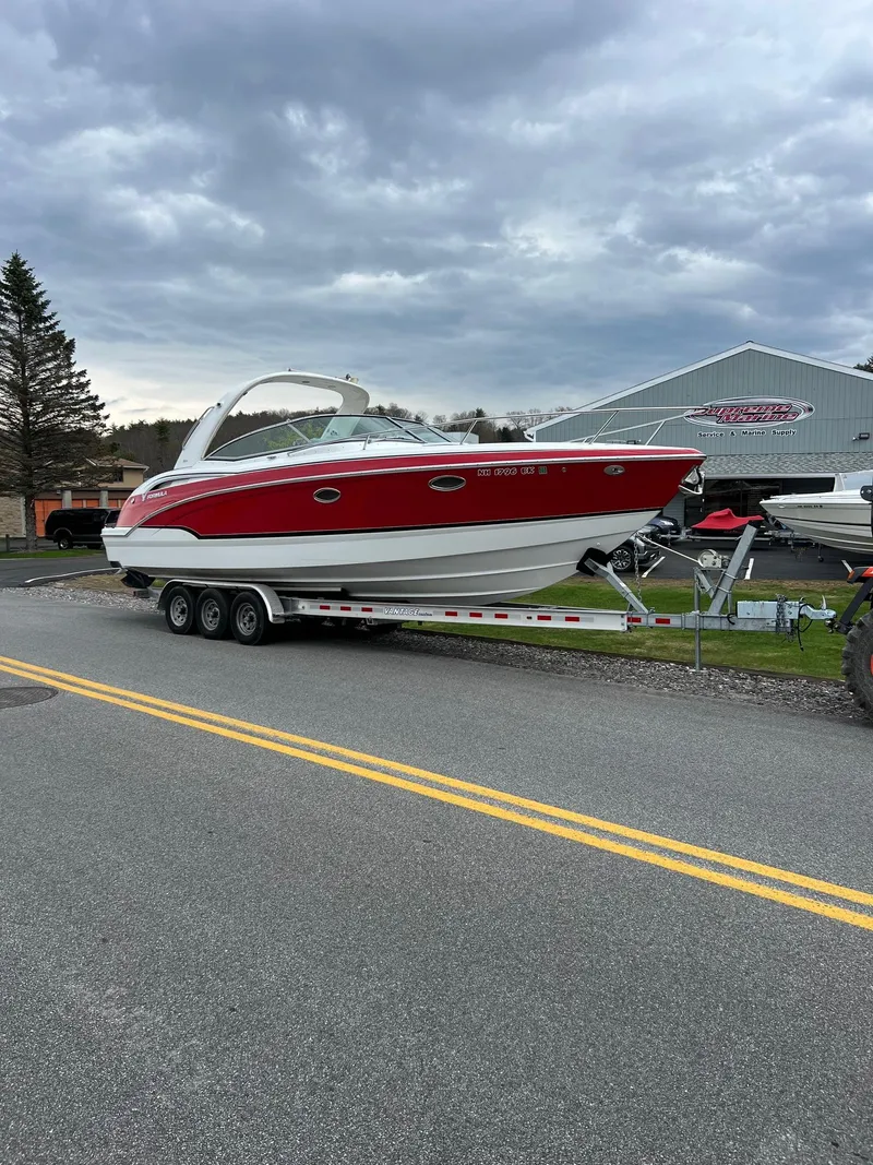 Slide: The Image of 2007 Formula 310SS boat on a trailer, red and white, parked on a road. - 1