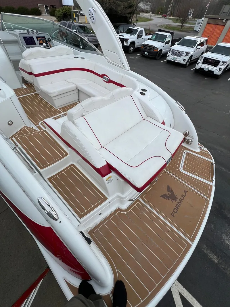 Slide: The Image of 2007 Formula 310SS boat with white and red seating, docked near parked cars. - 10
