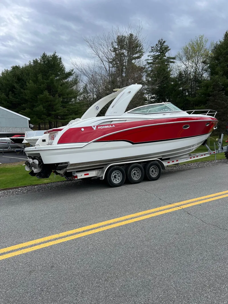 Slide: The Image of 2007 Formula 310SS boat on a trailer, red and white, parked on a road. - 12